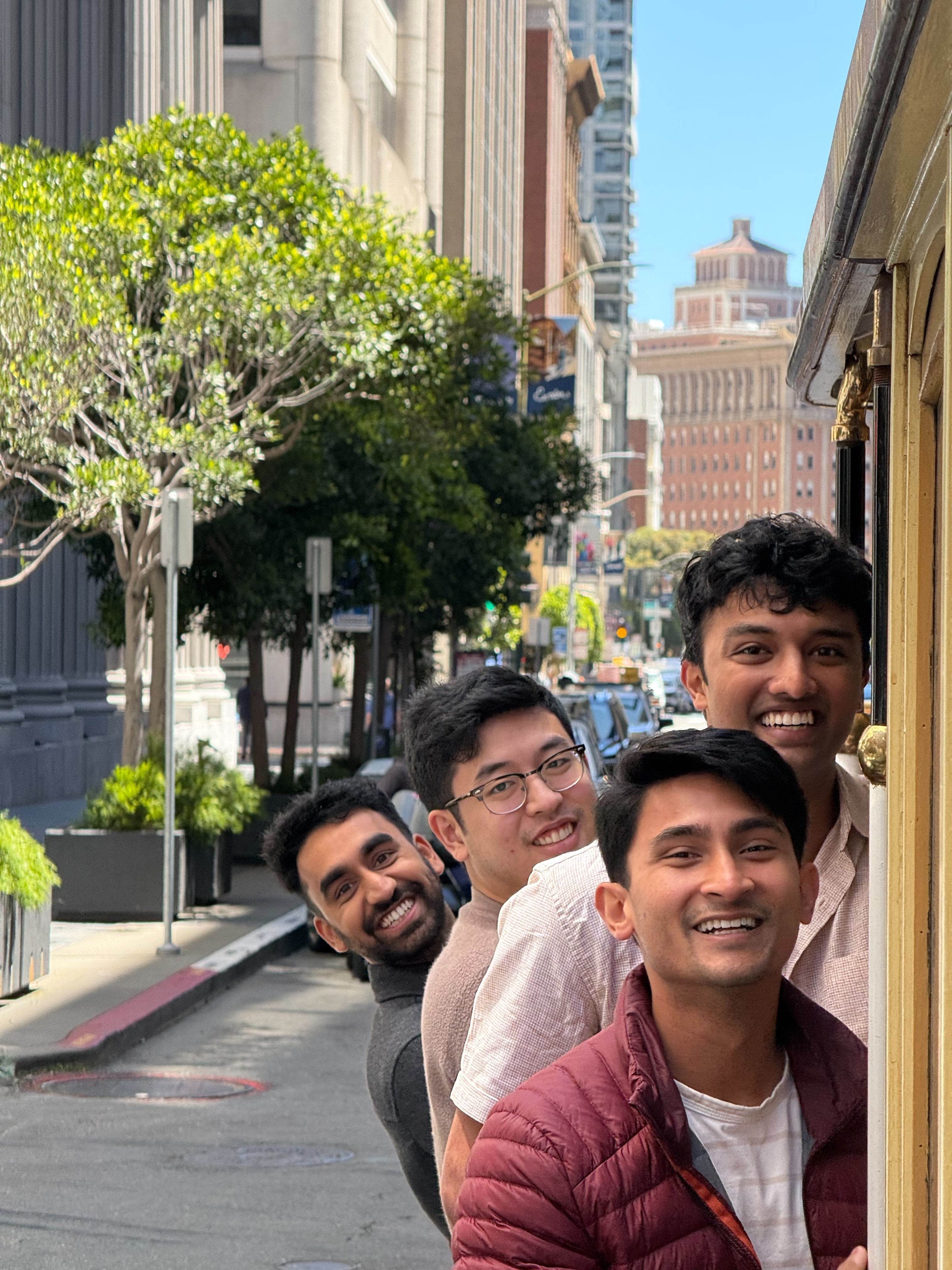 Folks hanging off the side of a cable car